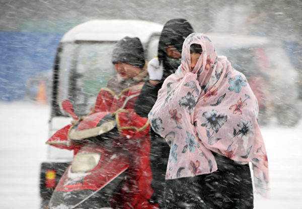 近日，江苏、浙江、上海等8省市下大雪，局地暴雪。图为雪中的南通居民。(AFP/Getty Images)