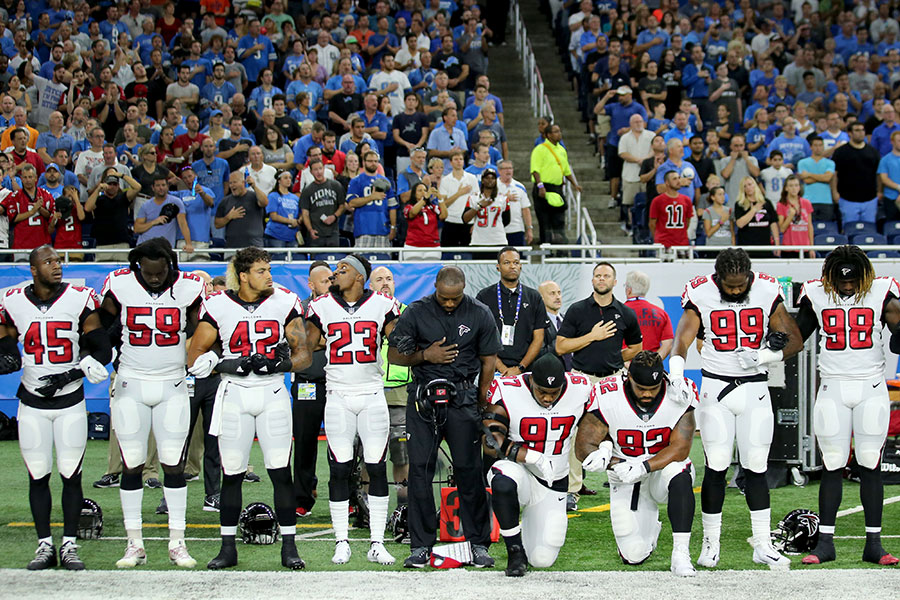 川普批評美國橄欖球聯盟(NFL)的隊員在賽場播放國歌時,拒絕起立的做法。圖為2017年9月24日在密歇根舉行的一場NFL賽事中,有部分球員在奏國歌時採取單膝下跪的姿勢。(Leon Halip/Getty Images)