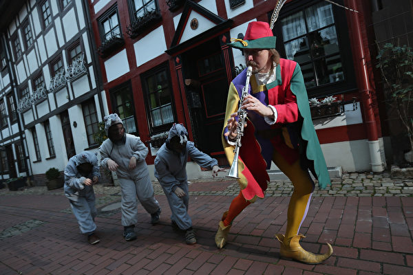 2012年11月19日，哈默尔恩市的旅游局职员装扮成花衣吹笛人，带领扮作老鼠的孩子在市内走过。(Sean Gallup/Getty Images)