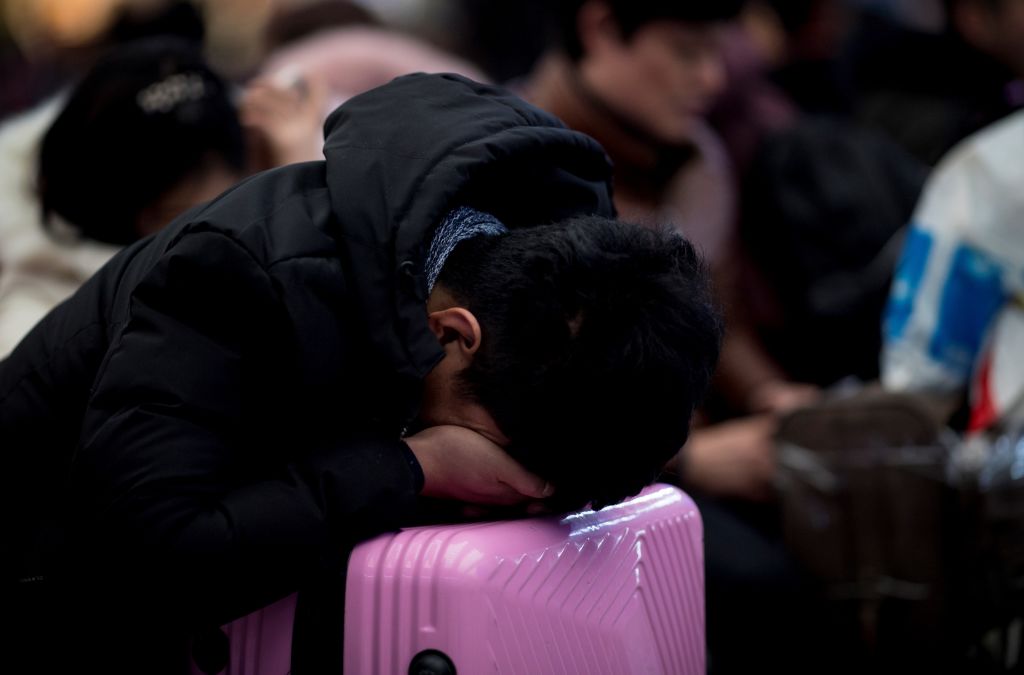2月1日,上海虹桥火车站,一名乘客在休息片刻。(JOHANNES EISELE/AFP/Getty Images)