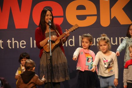 “儿童周”上，歌手和儿童一起演唱美国传统民谣“这土地是你的土地”（This Land is Your Land）。