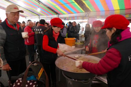 社区志工为民众盛装热腾腾的冬笋汤。