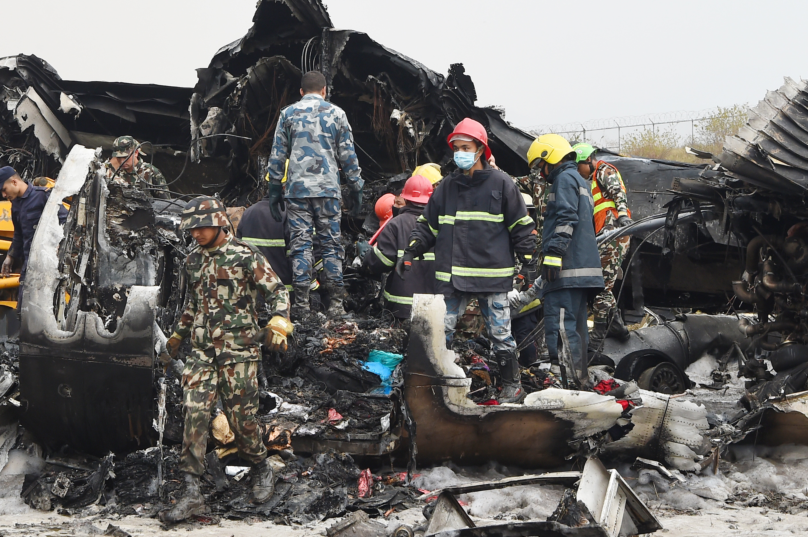 救援人员在飞机坠毁现场寻找生还者及挖掘尸体。(PRAKASH MATHEMA/AFP/Getty Images)