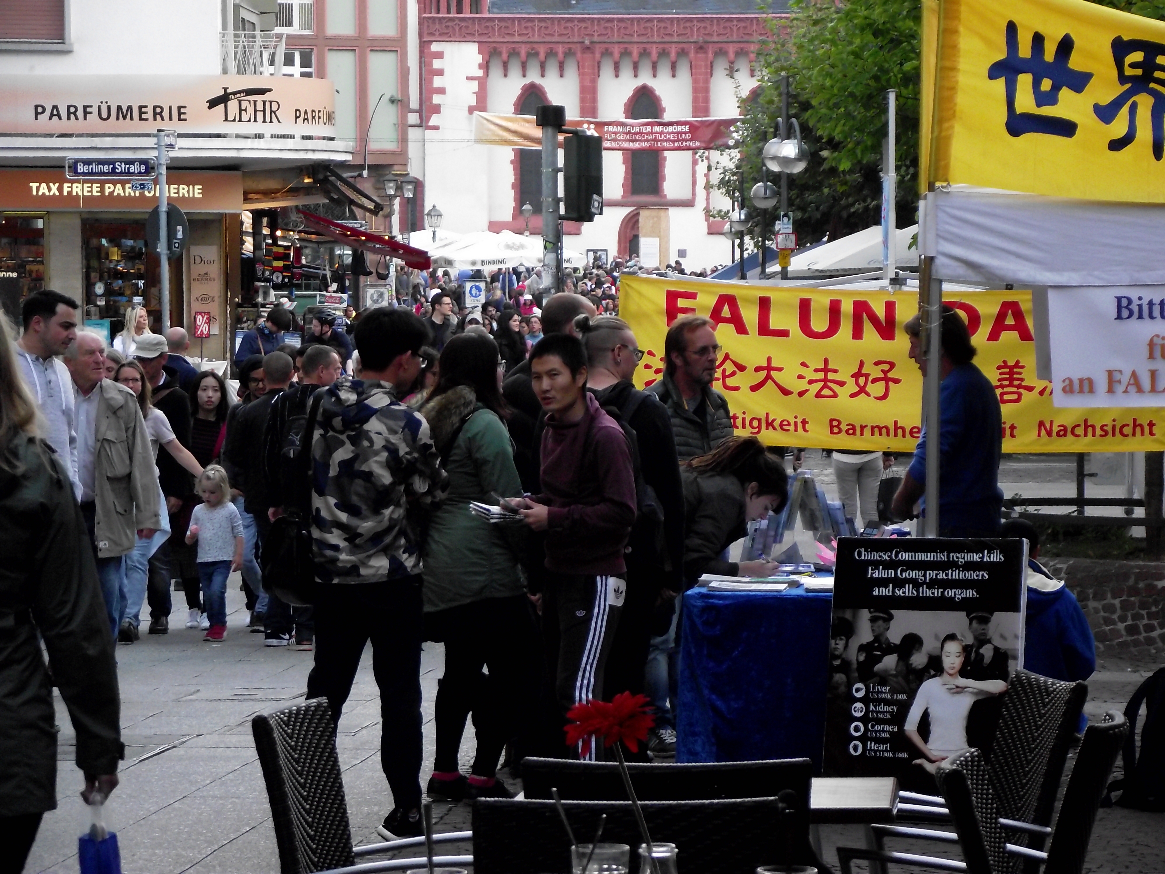 每天有大量的大陆游客在法兰克福市内柏林大道的景点可以看到法轮功信息台上的真相横幅、展板。(明慧网)