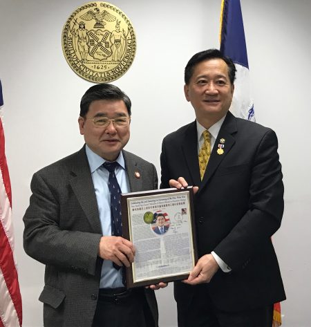 美国邮政纪念卡筹备委员会委员朱林骥（右）向市议员顾雅明（左）致送祝贺他三连任市议员的美国邮政纪念卡。