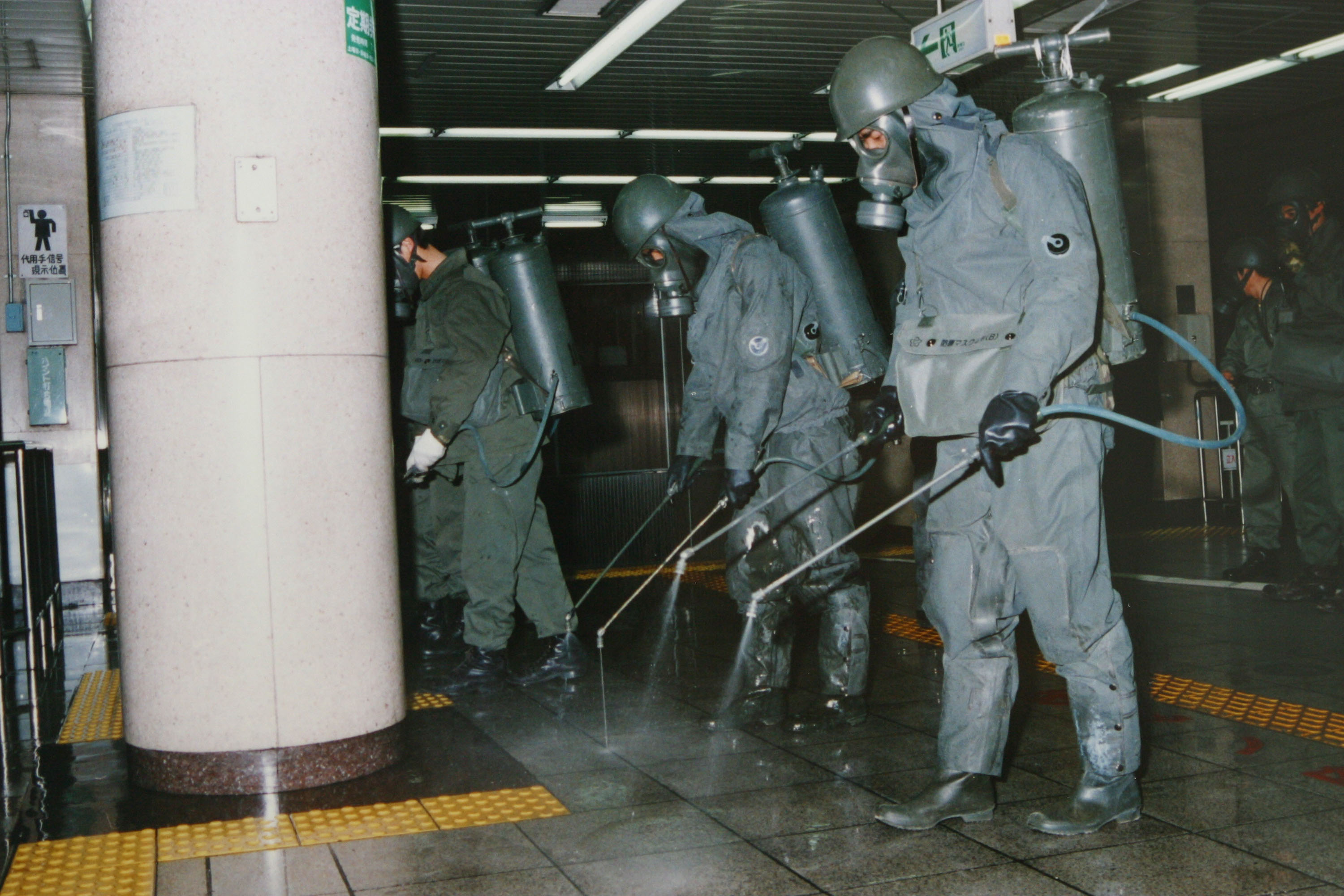 東京沙林毒氣攻擊發生後，相關人員在清除站台上的沙林。(Japanese Defence Agency/Getty Images)