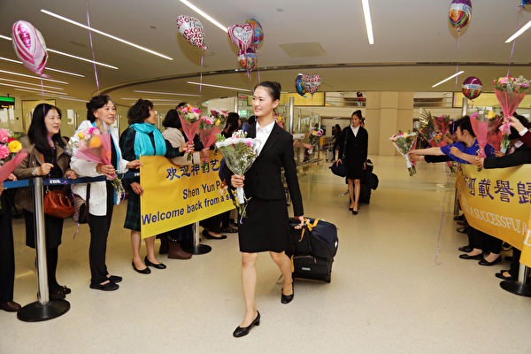 神韻紐約藝術團載譽返美，部分成員步入紐瓦克機場大廳，受到歡迎。（張學慧／大紀元）