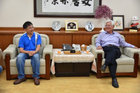 县长李进勇（右）接见嵩岳咖啡庄园咖啡农郭章盛（左），肯定他对咖啡种植的努力与成就。