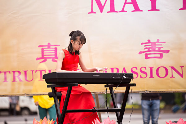 2018年5月10日，紐約部分法輪功學員在聯合廣場集體煉功，慶祝法輪大法日。Duo Duo表演鋼琴獨奏《走在神的路上》（戴兵／大紀元）