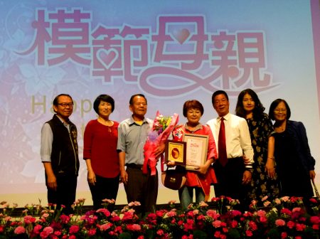 熱心公益的法輪功學員馬燕月(中) 當選模範母親，10日接受台東市長張國洲(右3)表揚。