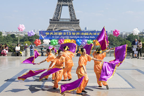 2018年5月20日在法國巴黎鐵塔對面的人權廣場上，法國部分法輪功學員用歌舞演出和功法演示慶祝第十九屆世界法輪大法日。（葉蕭斌/大紀元）