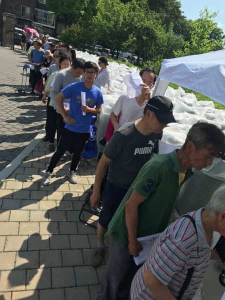 领雨桶的华人民众排长龙。