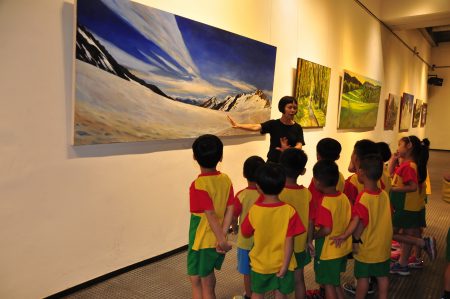 新竹市美术协会理事长江雨桐为小朋友导览画作，不忘带入生态环保观念机会教育