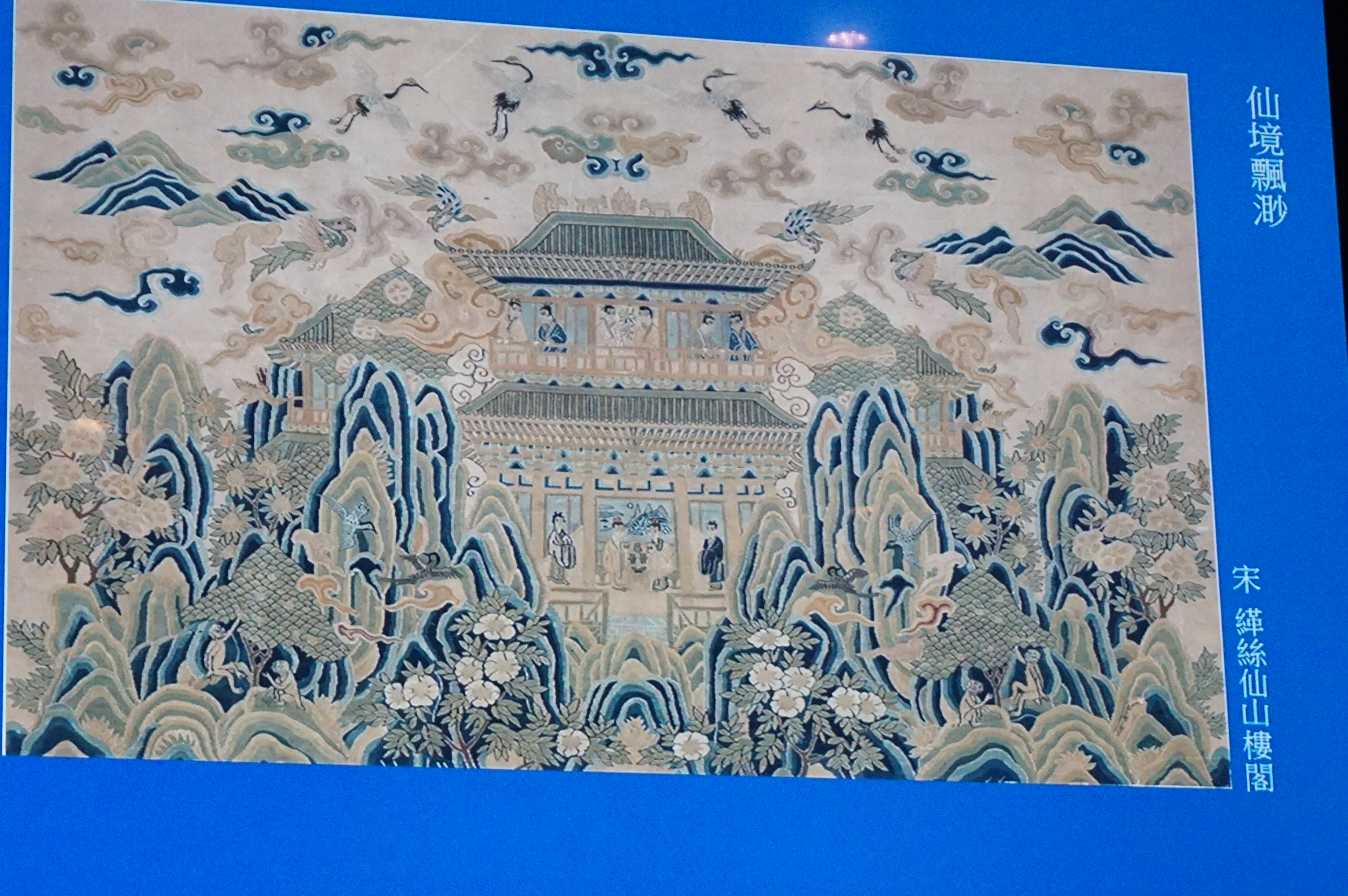 宋〈缂丝仙山楼阁〉画中有神鸟、丝猴摘果、神仙们在楼阁里谈笑。(李怡欣/大纪元)