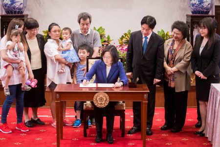 总统蔡英文（前）、行政院长赖清德（后右3）、总统府秘书长陈菊（后右2）等人6月6日在总统府公开签署“儿童及少年未来教育与发展账户条例”。
