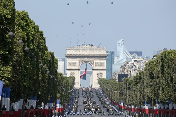A general view shows helicopters, members of the national police motorcycle units and military vehicles taking part in the annual Bastille Day military parade on the Champs-Elysees avenue near the Arc de Triomphe in Paris on July 14, 2018. 