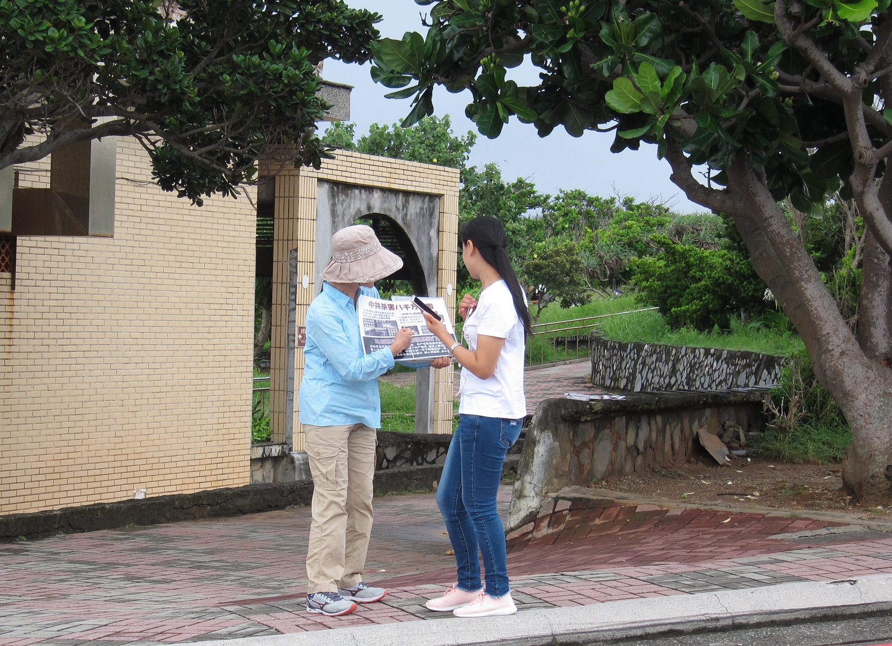 法輪功學員李芳花在墾丁貓鼻頭景點向遊客講真相。(簡惠敏/大紀元)