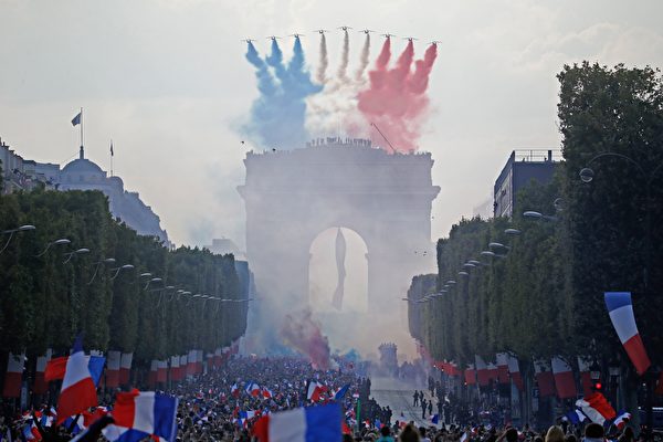7月16日，法国巡逻兵飞行表演队（Patrouille de France）拖着喷洒出的蓝白红法国国旗三色烟雾为英雄凯旋的庆典助兴，场面分外壮观。（CHARLY TRIBALLEAU/AFP/Getty Images）