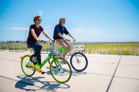 全球多处风行的无桩共享单车，13日也正式在纽约市面世，皇后区洛克威海滩步道被选为第一个试点运行项目。市长白思豪与市交通局局长乔顿博格并肩试骑。