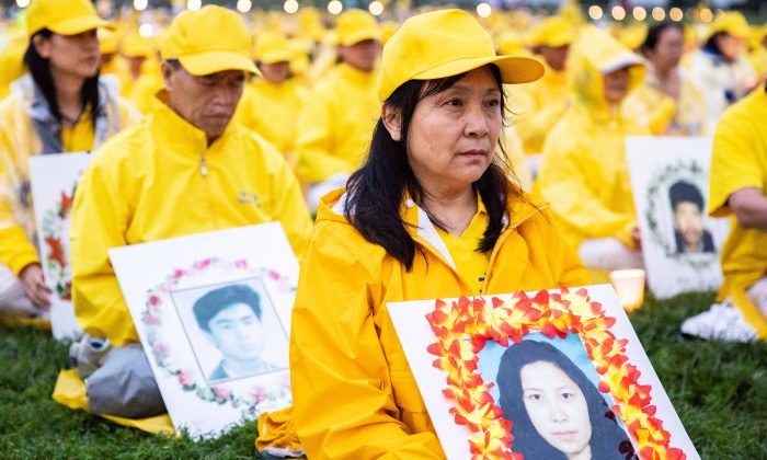 这张资料图片中,法轮功学员汇集美国华盛顿,悼念被迫害至死的同修。图为高莉莉手捧妹妹高蓉蓉遗像。(Samira Bouaou/大纪元)