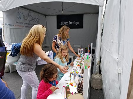 家長陪著孩子在3Dux Design攤位，用硬紙板製作火箭船。