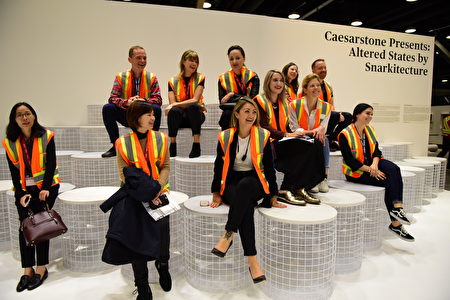 在温哥华室内设计展IDS上，由Caesarstone设计的前卫大理石板凳，这群媒体人个个欢天喜地坐在上面似乎不愿下来。（童宇/大纪元）