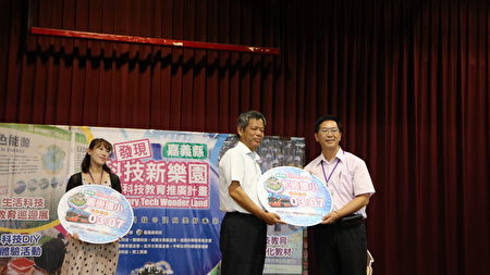 11. 嘉义县政府秘书长颜旭明为科技探索见学之旅，授牌给10个国小之一的和睦国小校长陈振兴(右)。