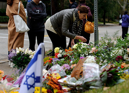 人們在街道上的一個臨時紀念館鋪設了一束束鮮花，悼念遇難者。