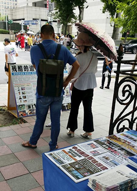 台北國父紀念館前，大陸遊客認真閱讀法輪功真相展板。（明慧網）