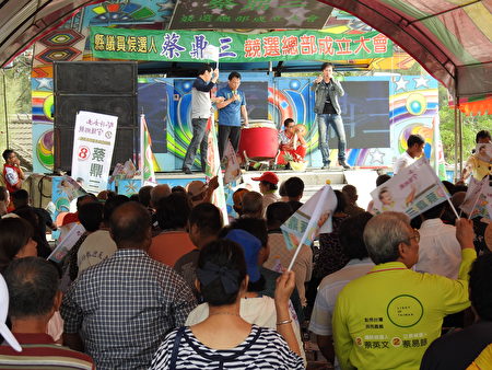 争取连任的民进党籍县议员蔡鼎三，20日举行竞选总部成立大会，名歌手郑君威（台上右1）到场高歌数曲炒热现场气氛，场面热烈。