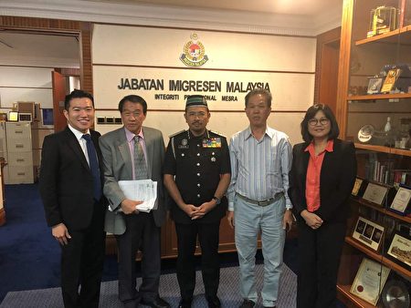 馬來西亞（旅美）聯誼會董事會主席邦君雄（左二）向馬來西亞移民局總監（Seri Mustafar Ali，中）遞交反映僑民護照問題的文件。
