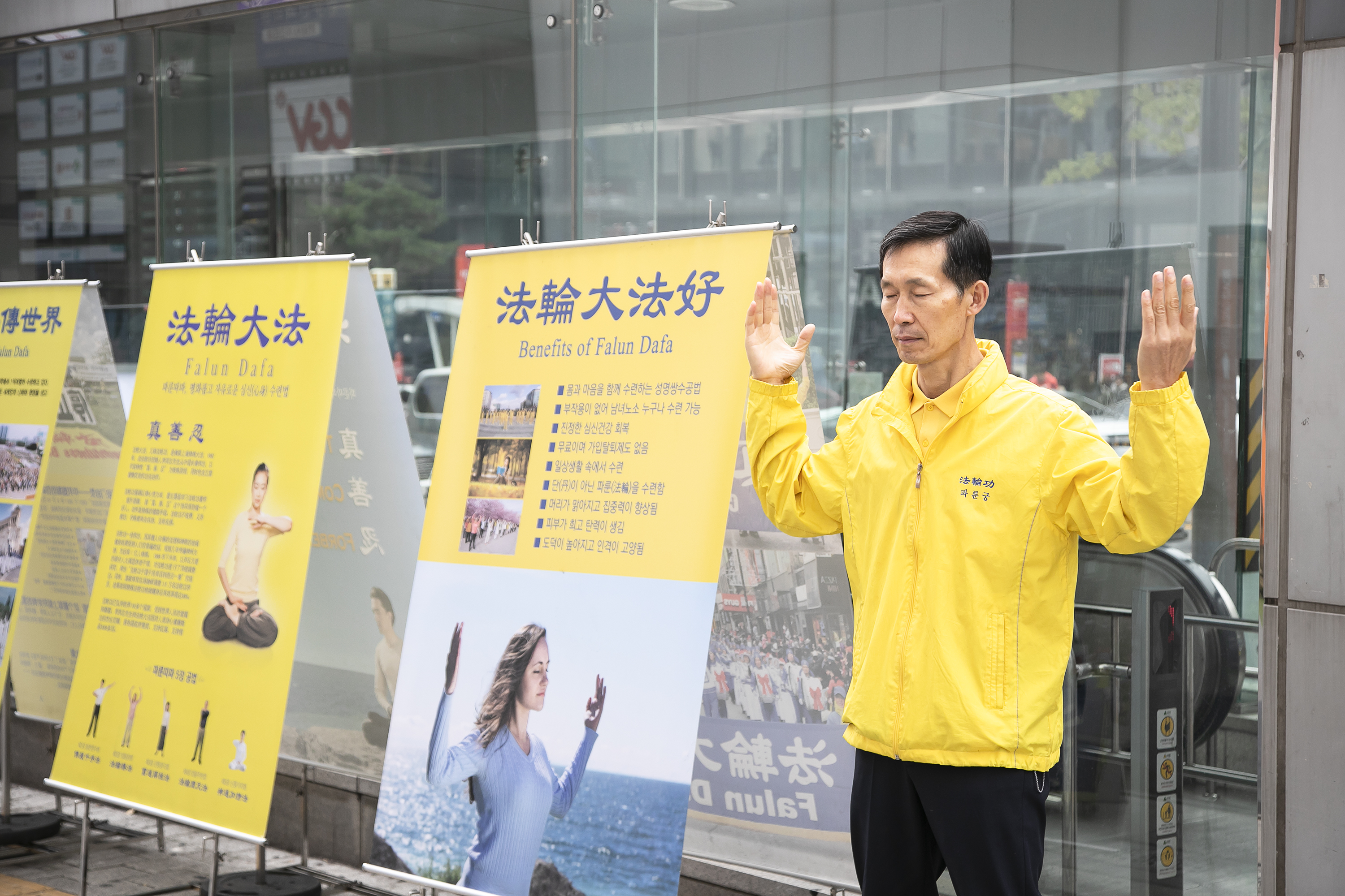 李重天利用周末休息时间，风雨无阻地到中国游客常去之地韩国南山下的韩屋村摆放真相展板讲真相。（全景林/大纪元）