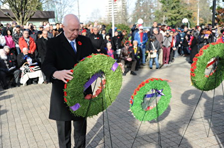 11月11日，本拿比市在南部青年活动中心举行荣军日纪念活动，缅怀为国捐躯的加拿大将士。图为本拿比市长侯迈豪（Mike Hurley）献花环。