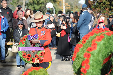 11月11日，本拿比市在南部青年活动中心举行荣军日纪念活动，缅怀为国捐躯的加拿大将士。图为皇家骑警代表敬献花环。