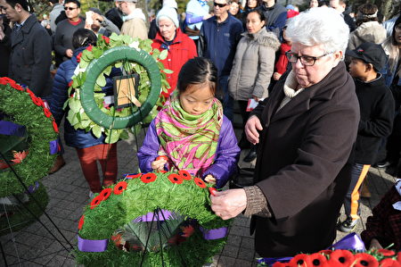 11月11日，本拿比市在南部青年活動中心舉行榮軍日紀念活動，緬懷為國捐軀的加拿大將士。圖為參加紀念活動的市民獻上罌粟花。
