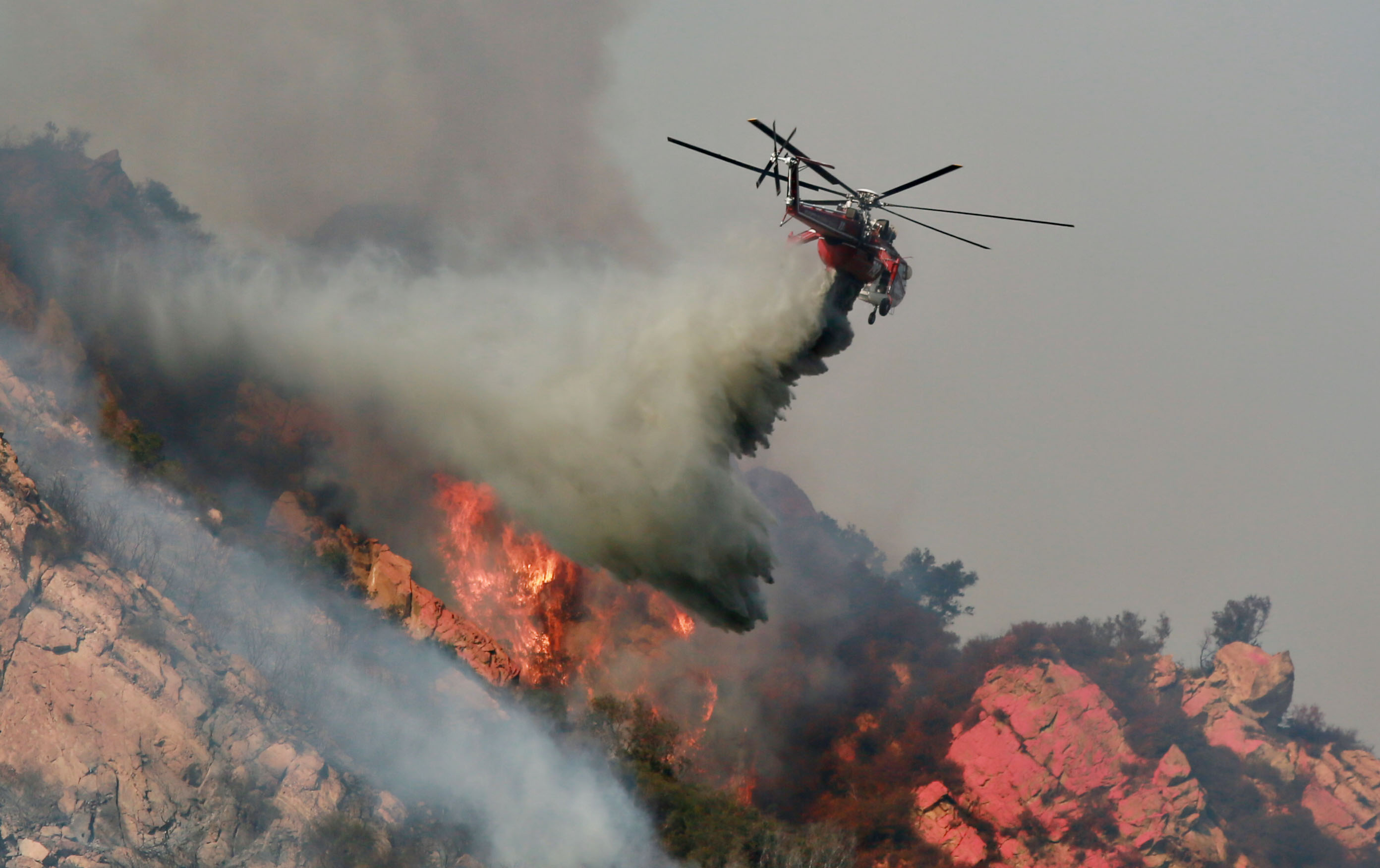 图为直升机在“伍尔西大火”肆虐的地区灭火。(Sandy Huffaker/Getty Images)
