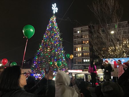 法拉盛图书馆广场的圣诞树点亮，民众争相拍照。