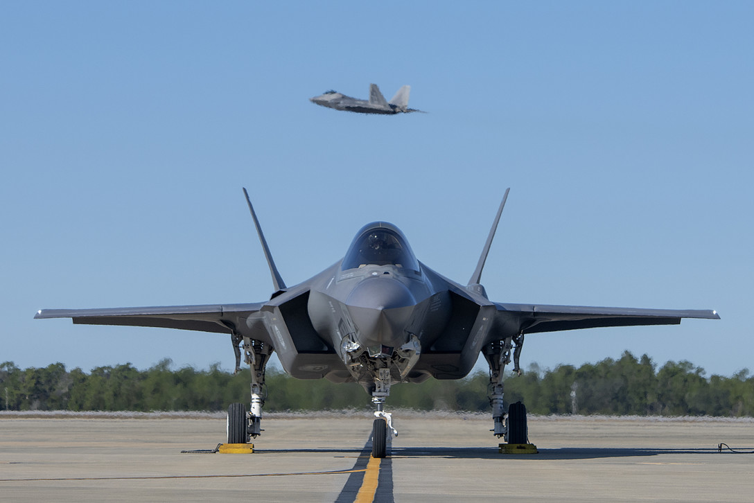 2018年12月4日,美國空軍一架F-35A戰機在佛羅里達州的空軍基地準備滑行,其後方有一架F-22戰機在飛行。(Peter Thompson/U.S. Air Force)