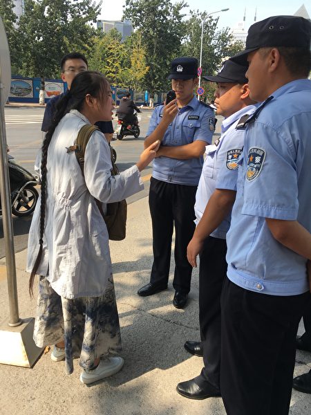 在山东省省委门前，警察要把李宁带到信访局。她向警察讲诉母亲的案子过程！最终仍被带走！（受访者提供）