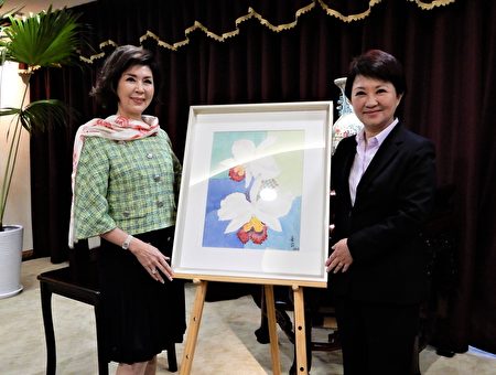 白嘉莉(左)捐赠一幅亲笔绘制的兰花做公益拍卖，并允诺在台中办画展及新书发表会。