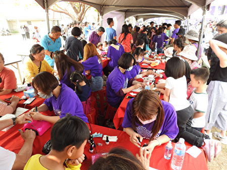 嘉义县举办“幸福女力 闪耀魅力”妇女节活动，在“闪耀魅力区”民众参与指甲彩绘的热闹场景。