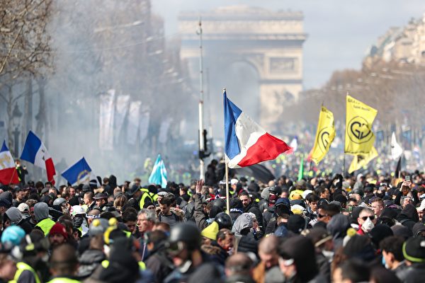 3月16日，黄背心示威者集结在巴黎香榭丽舍大道上，有些人穿着黄色背心，但许多身穿黑衣、带黑帽子或头盔且蒙面的人也与抗议者混在一起。（ZAKARIA ABDELKAFI/AFP/Getty Images）