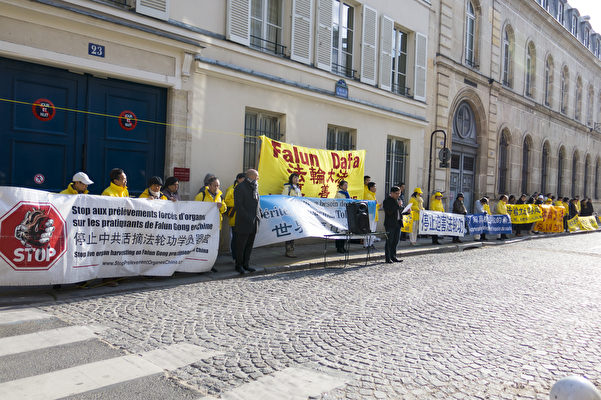 法輪功學員在中共駐巴黎使館前打出「停止中共活摘法輪功學員器官」、「世界需要真善忍」、「停止迫害法輪功」等橫幅。（關宇寧/大紀元）