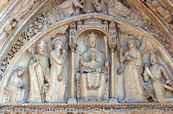 巴黎圣母院正面右侧的圣安妮之门，门楣上的主角是宝座上的圣母子。(shutterstock)