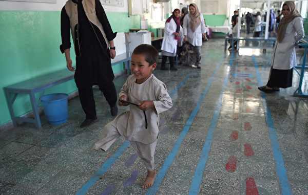 Ahmad Sayed Rahman, a five-year-old Afghan boy who lost his right leg when he was hit by a bullet in the crossfire of a battle, walks without his prosthetic leg at the International Committee of the Red Cross (ICRC) hospital for war victims and the disabled, in Kabul on May 7, 2019. - With his hands in the air and an infectious grin spreading from ear to ear, a young Afghan boy whirls around a Kabul hospital room on his new prosthetic leg. The boy, five-year-old Ahmad Sayed Rahman, has become a social media star in Afghanistan and beyond after a short video of him effortlessly dancing on his new limb was published this week on Twitter. (Photo by WAKIL KOHSAR / AFP) (Photo credit should read WAKIL KOHSAR/AFP/Getty Images)