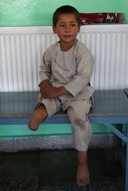 Ahmad Sayed Rahman, a five-year-old Afghan boy who lost his right leg when he was hit by a bullet in the crossfire of a battle, sits on a bench without his prosthetic leg at the International Committee of the Red Cross (ICRC) hospital for war victims and the disabled, in Kabul on May 7, 2019. - With his hands in the air and an infectious grin spreading from ear to ear, a young Afghan boy whirls around a Kabul hospital room on his new prosthetic leg. The boy, five-year-old Ahmad Sayed Rahman, has become a social media star in Afghanistan and beyond after a short video of him effortlessly dancing on his new limb was published this week on Twitter. (Photo by WAKIL KOHSAR / AFP) (Photo credit should read WAKIL KOHSAR/AFP/Getty Images)