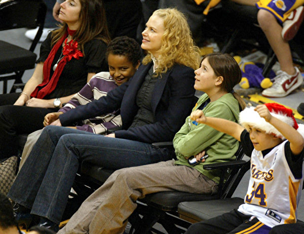 2004年12月25日，妮可基嫚（中）和养子康纳（左中）和养女伊莎贝拉（右二）在洛杉矶观看NBA赛事。(Matthew Simmons/Getty Images)