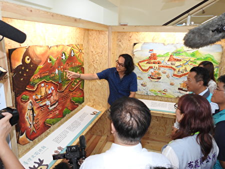 导览人员为嘉义县长翁章梁等贵宾，导览解说“布袋五四三布袋小镇展示所”“布袋历史五四三”主题之展示画作。