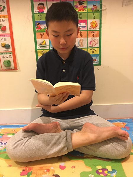 王漢在讀《轉法輪》。（趙芬妮／大紀元）