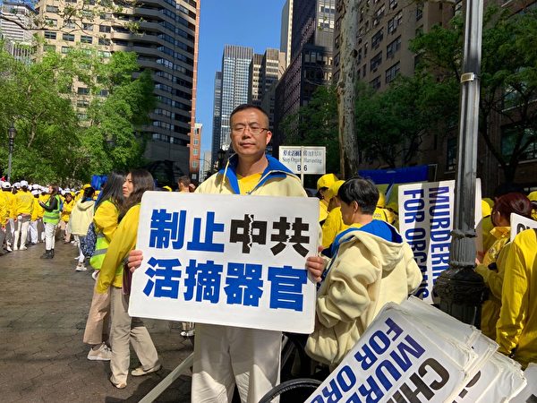 2019年5月16日在紐約曼哈頓舉行法輪功萬人大遊行，尹信曉打出「制止中共活摘器官」的展板。（尹信曉提供）